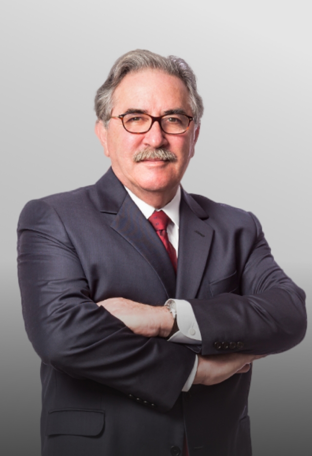 José Lúcio Glomb, advogado, OAB/PR 6.838. Conselheiro Federal da OAB, Ex-presidente do Instituto dos Advogados do Paraná - IAP e Presidente da OAB/PR de 2010 a 2012. Advogado de cabelos brancos, óculos de grau, terno azul e gravata vermelha.
